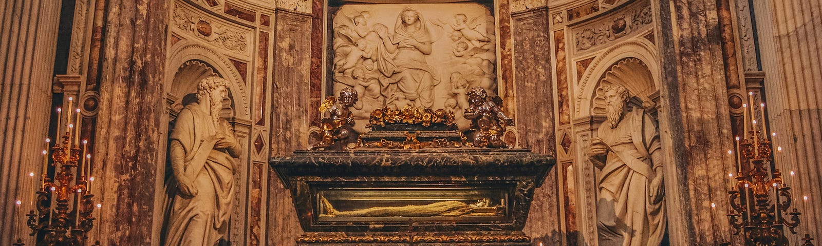Antique classical tomb inside a domed ornate church.