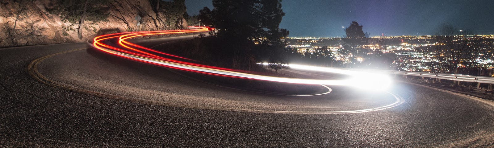 timelapse photography on curved road beside tree