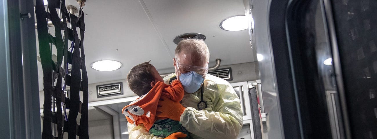 Paramedic Randy Lilly carries a 10-month-old boy on April 4, 2020 in Connecticut.