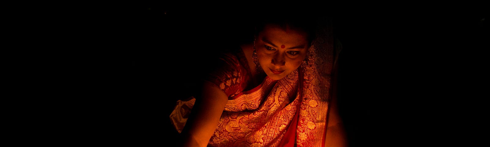 Woman lighting candles for Diwali.