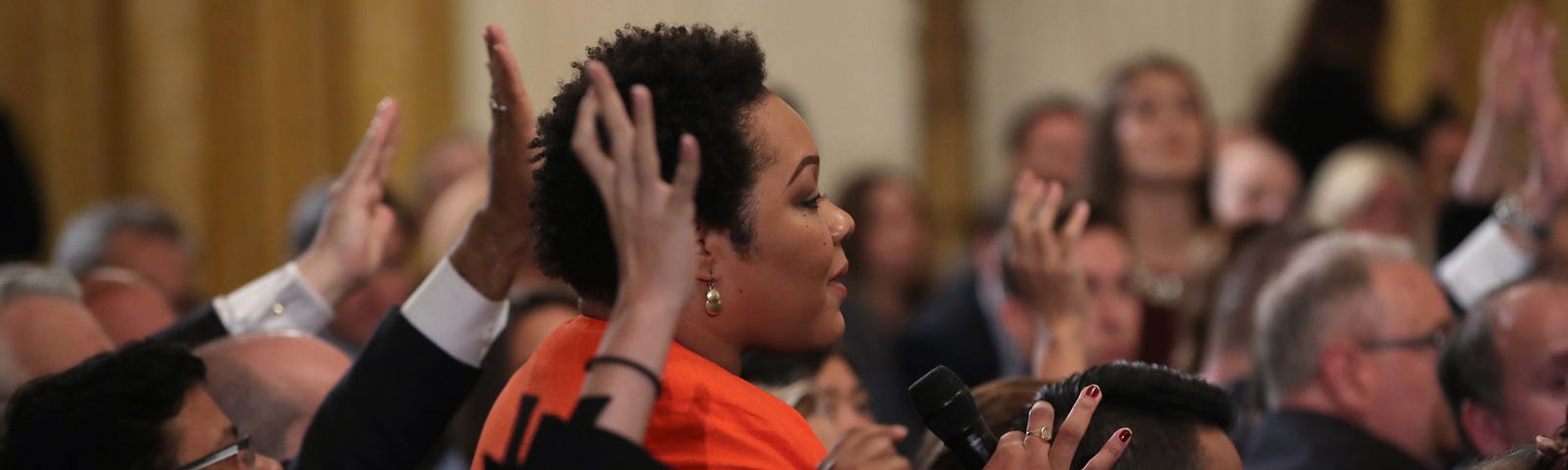 A photo of Yamiche Alcindor asking Trump a question at a press briefing.