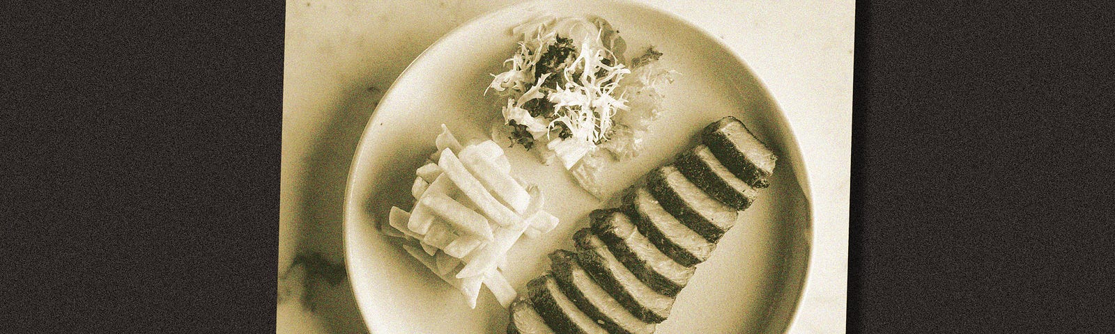 A plated dish with steak, salad, and a side.