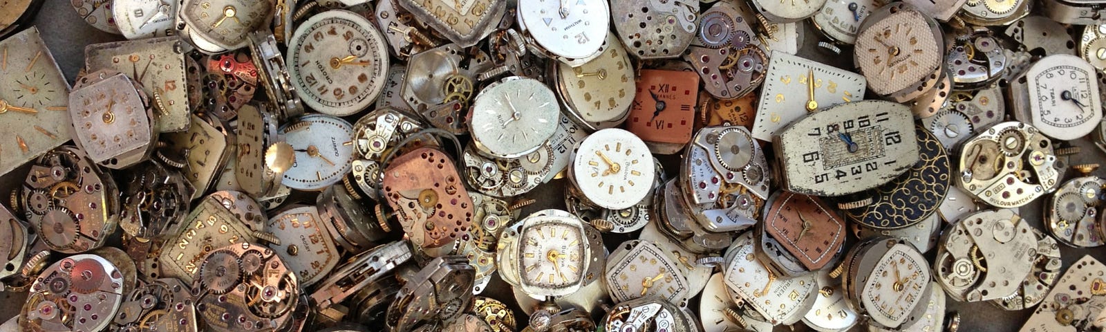 Photograph of pile of antique wrist watches.