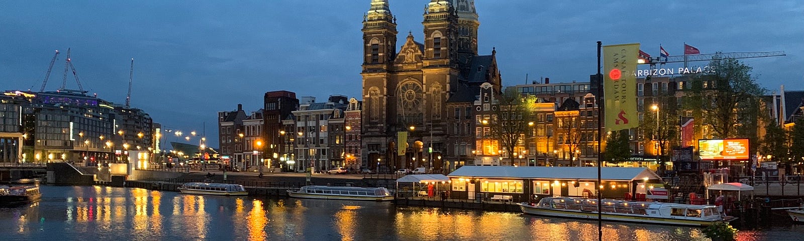 Evening view of Amsterdam by the water, the beautiful lights reflected in the water