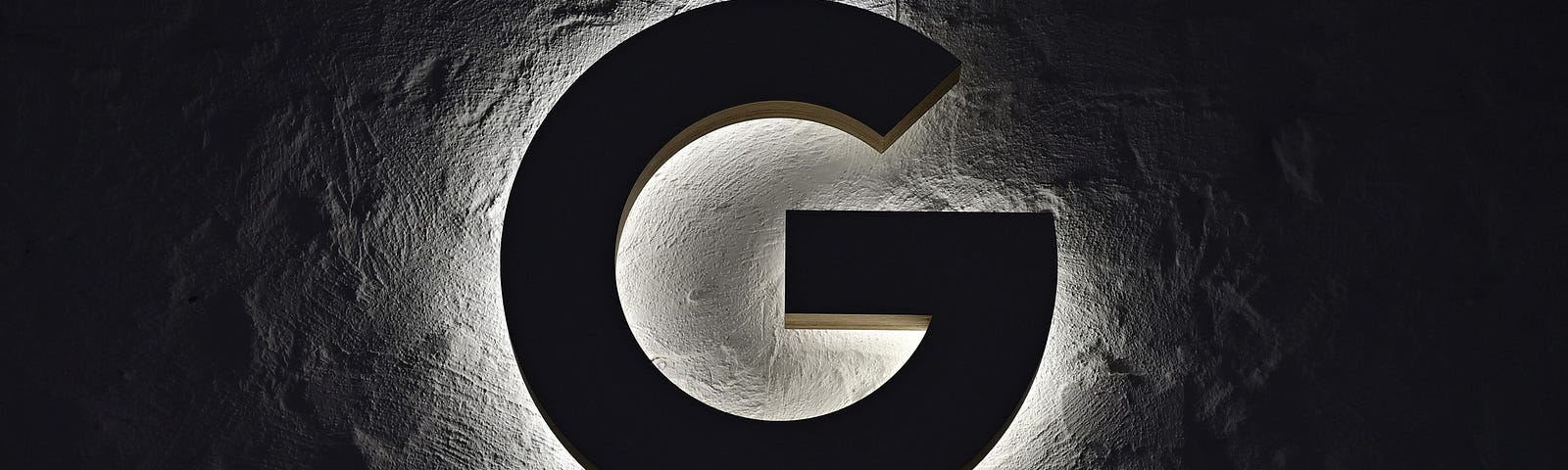 An illuminated “G” hangs on the wall.