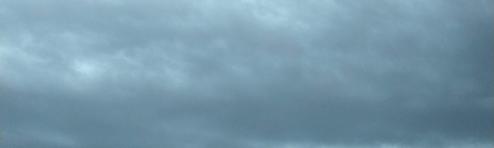 A canopy of blue clouds shelters the mountains.