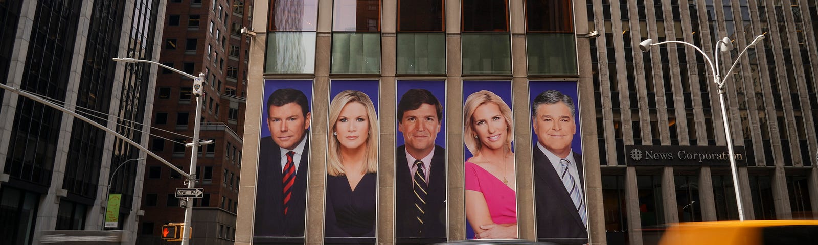 Bret Baier, Martha MacCallum, Tucker Carlson, Laura Ingraham, Sean Hannity as ads on the front of the News Corp building.