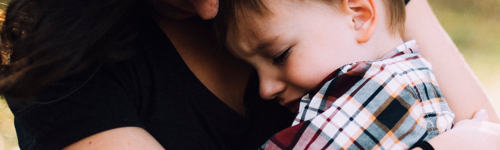 Dark haired woman comforting a young child