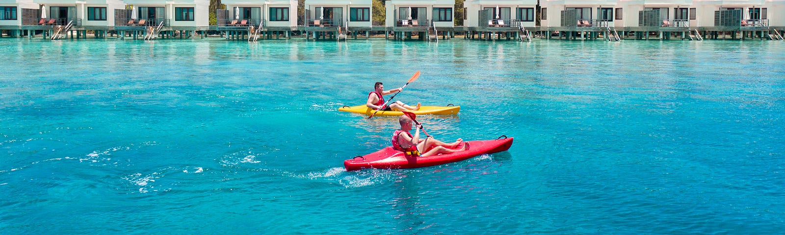 Photographs of two people on kayaks with holiday appartments in the background.