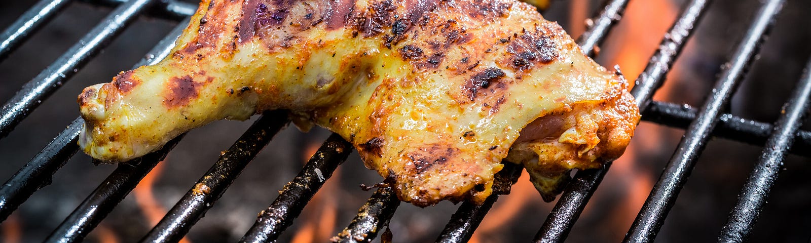 Chicken legs cooking on a grill.