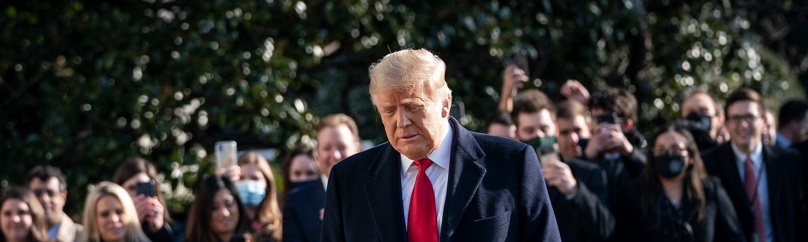 Donald Trump turns from reporters as he exits the White House to walk toward Marine One on the South Lawn on January 12, 2021