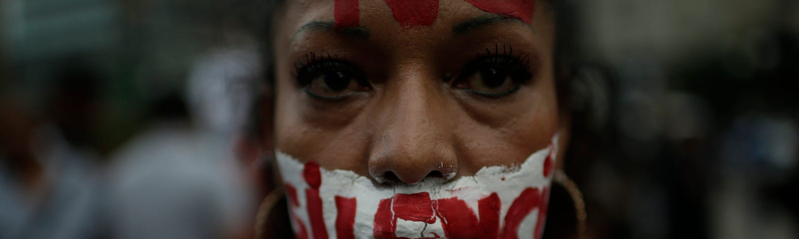 A woman with writing on her face that reads ‘no to silence’ looks at the camera during a demonstration in Mexico.