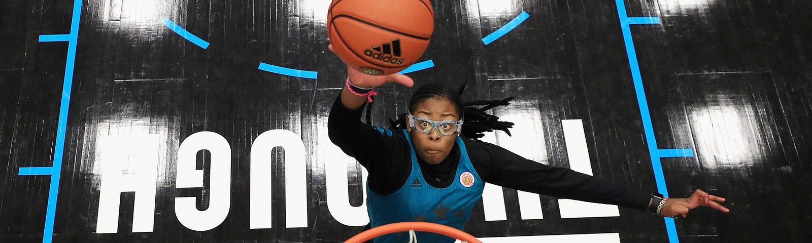 A photo of Francesca Belibi dunking on the court.