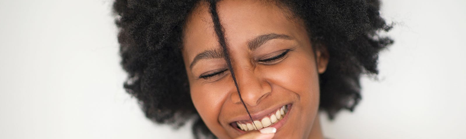 Smiling Black woman with natural hair.