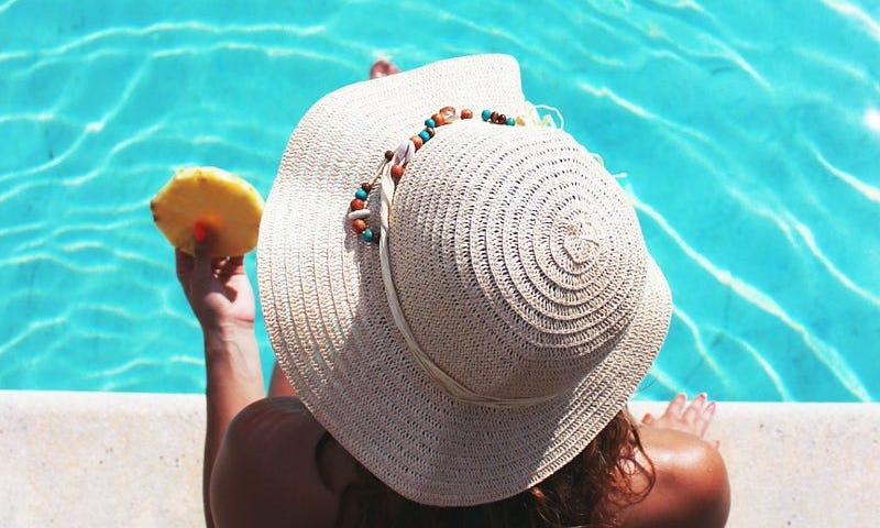 Picture of lady poolside, where some bees seem to attack