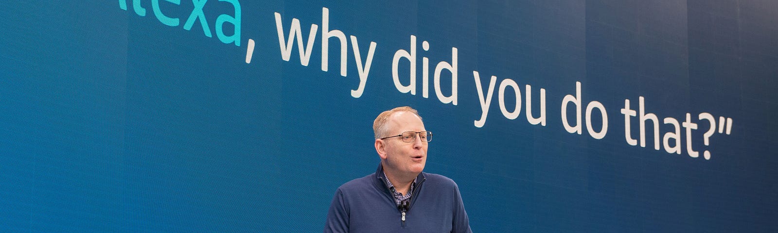 Amazon senior VP Dave Limp demonstrates a new Alexa feature. The text “Alexa, why did you do that?” is showcased behind him.