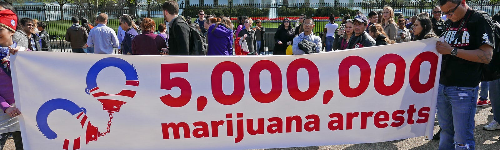 A group in front of the White House, holding a banner that says “5 million marijuana arrests”