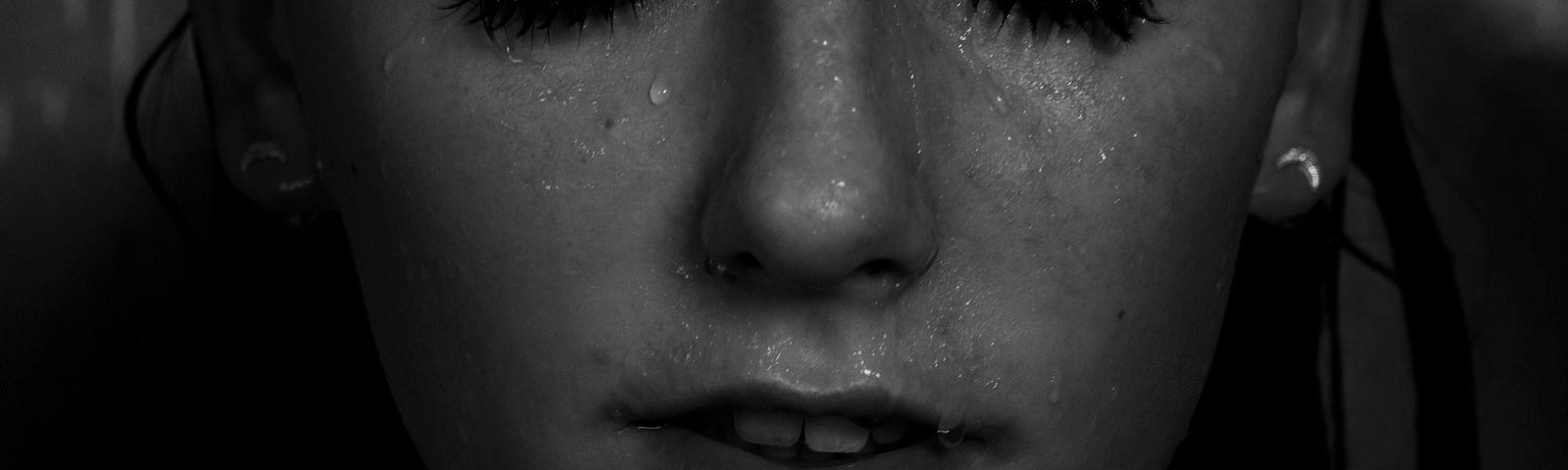 Grayscale photography of topless woman with water drops on face