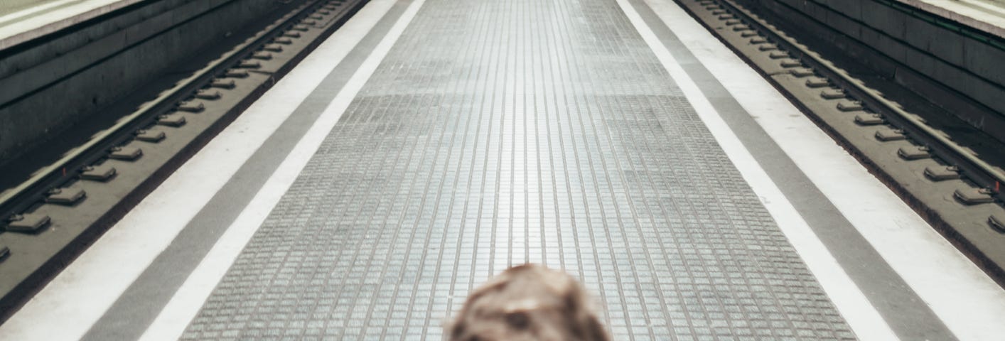 Little boy on an empty subway platform.