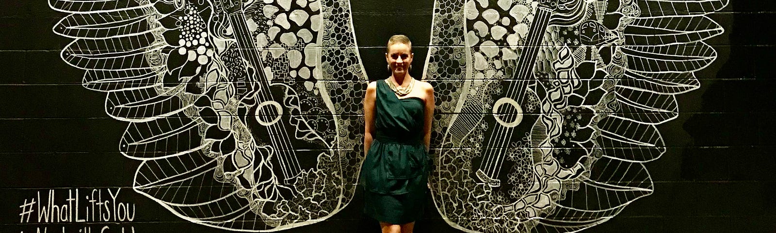 A photo of the author’s wife in front of a wall painting of wings.