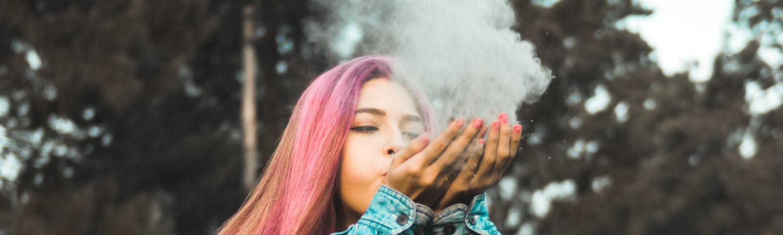 A woman blowing smoke out of her hands