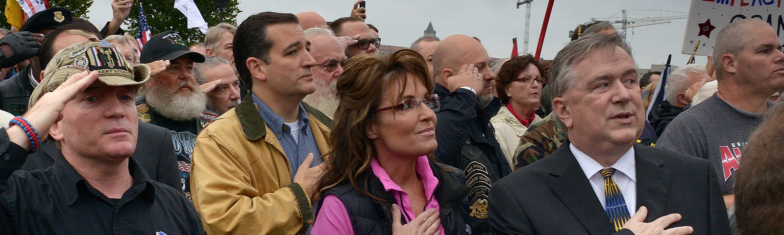 Former VP candidate Sarah Palin, Sen. Ted Cruz (R-TX), and others hold their hands over their hearts at a rally.