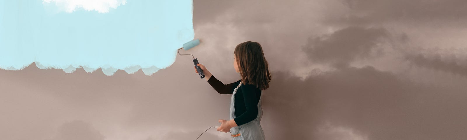 A girl paints the wall from a cloudy a clear blue sky.