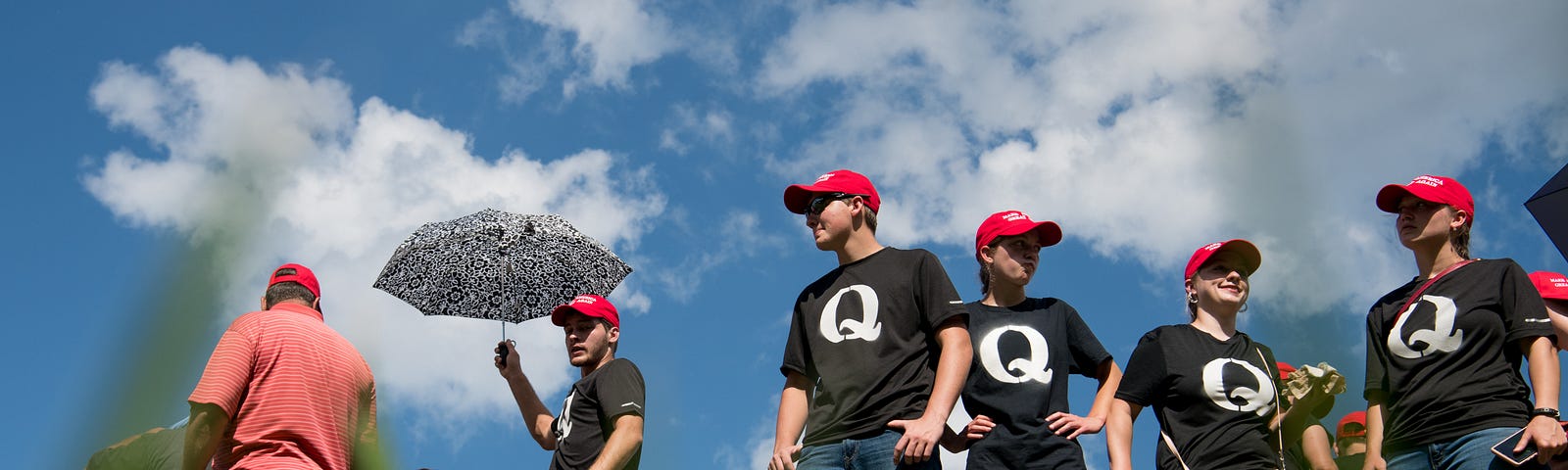 Supporters of President Donald Trump wearing ‘QAnon’ t-shirts wait in line before a campaign rally at Freedom Hall on 10/1/18