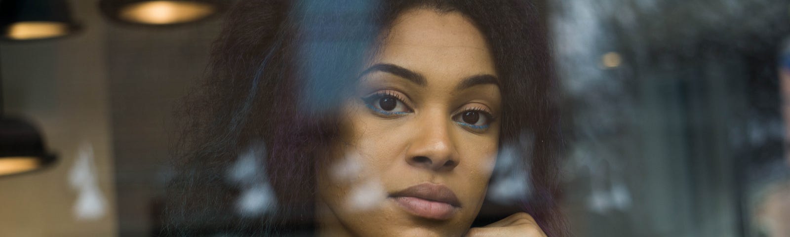 Mixed-race woman looking out a window.