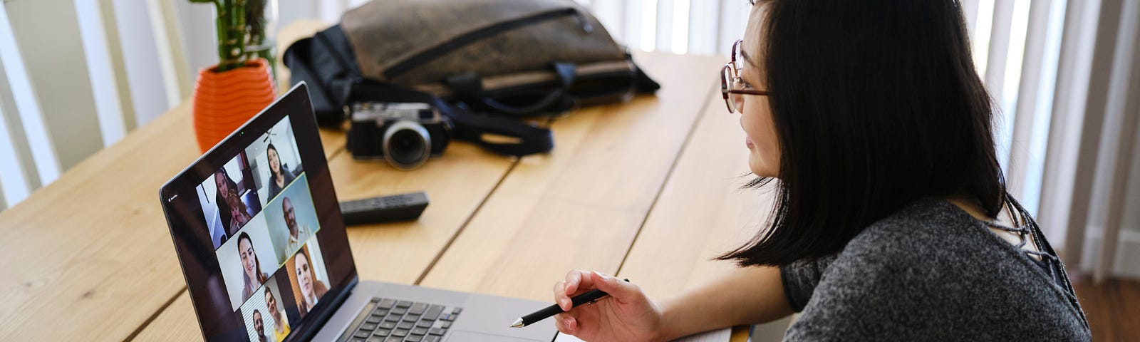 A woman working at home participating in a team video conference call.