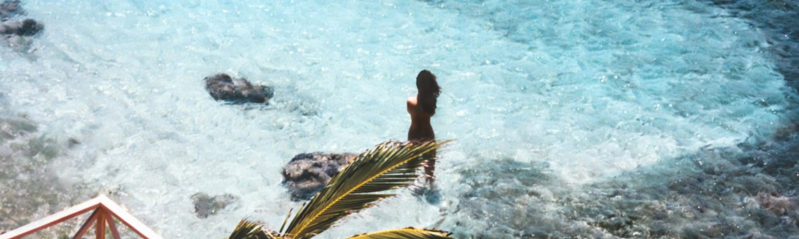 Baring it all, a female skinny-dipping in turquoise waters shaped into a heart. Women and body positive awareness.