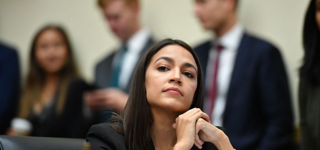 Representative Alexandria Ocasio-Cortez listens during a hearing.