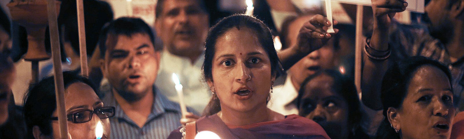 A photo of Indian protestors holding a candlelight march.