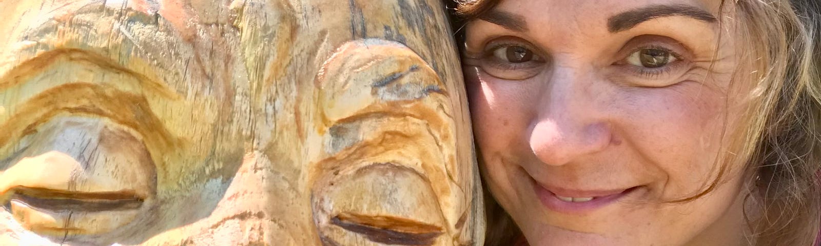 A selfie with a wooden carving of the Happy Buddha.