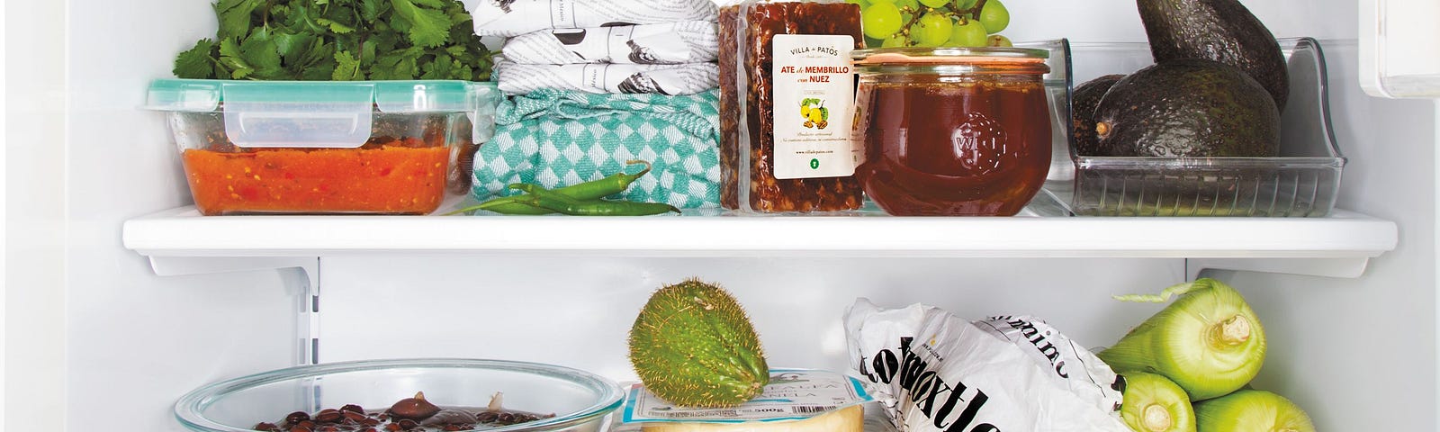 The inside of a fridge full of veggies.