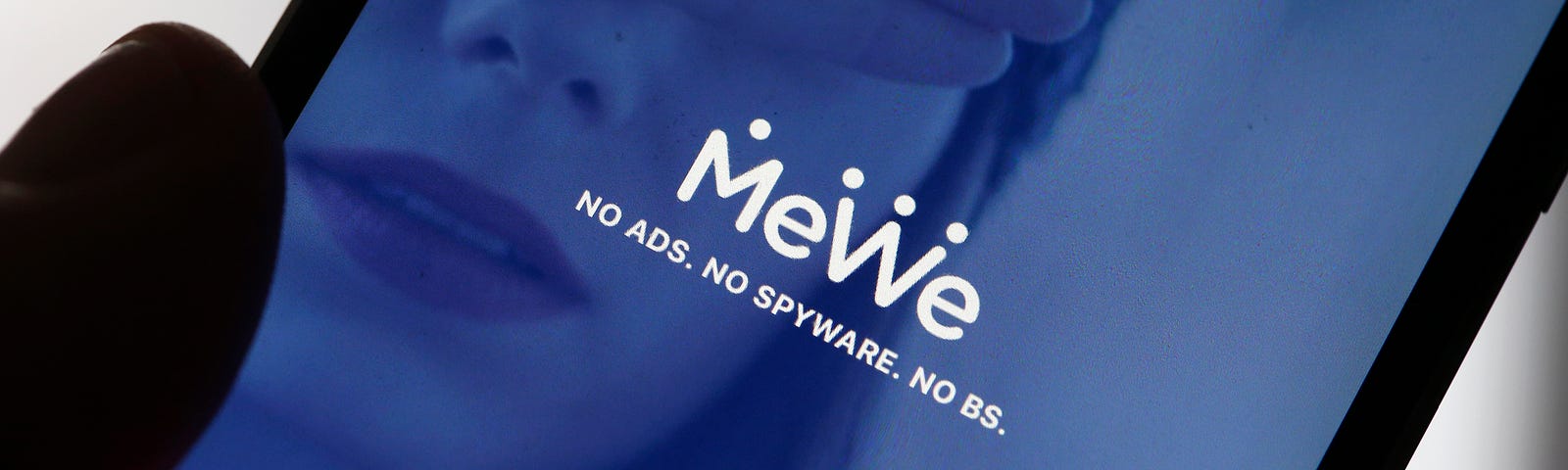 A photo illustration of the home page of the social media application MeWe displayed on the screen of an iPhone.