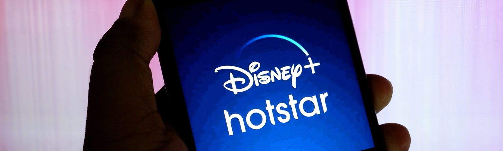 A Disney+ and Hotstar company logo seen displayed on a smartphone