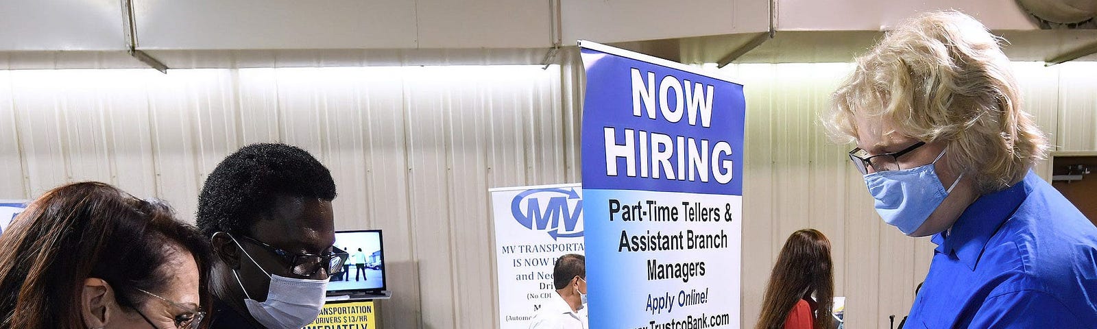 A man hands his resume to an employer at a job fair.