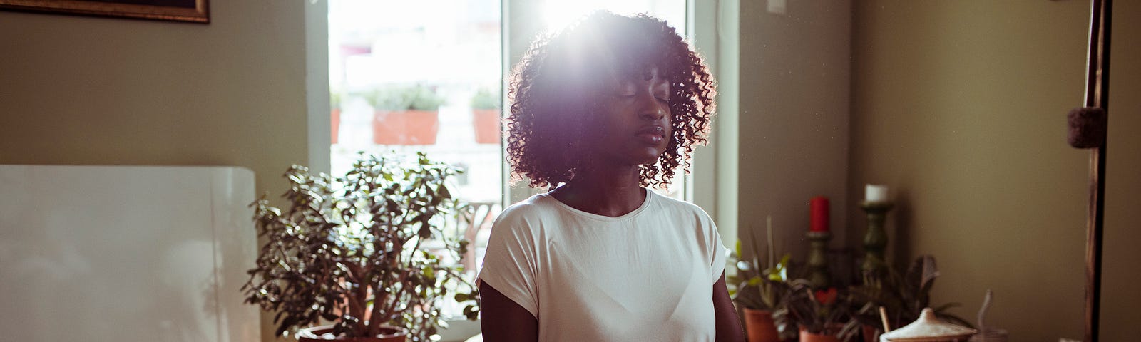 Black woman meditating in the living room.