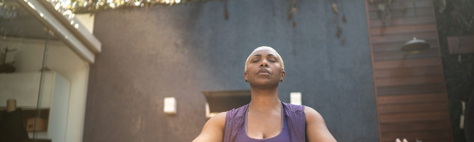 Woman meditating in the backyard.