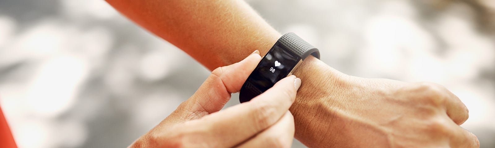 A close up of a person checking a wearable fitness tracker on their wrist.