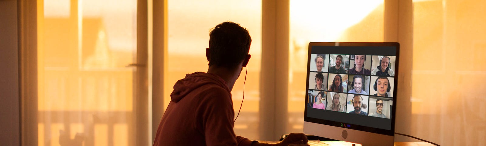 Young man distracted while on video call from his home during lockdown.