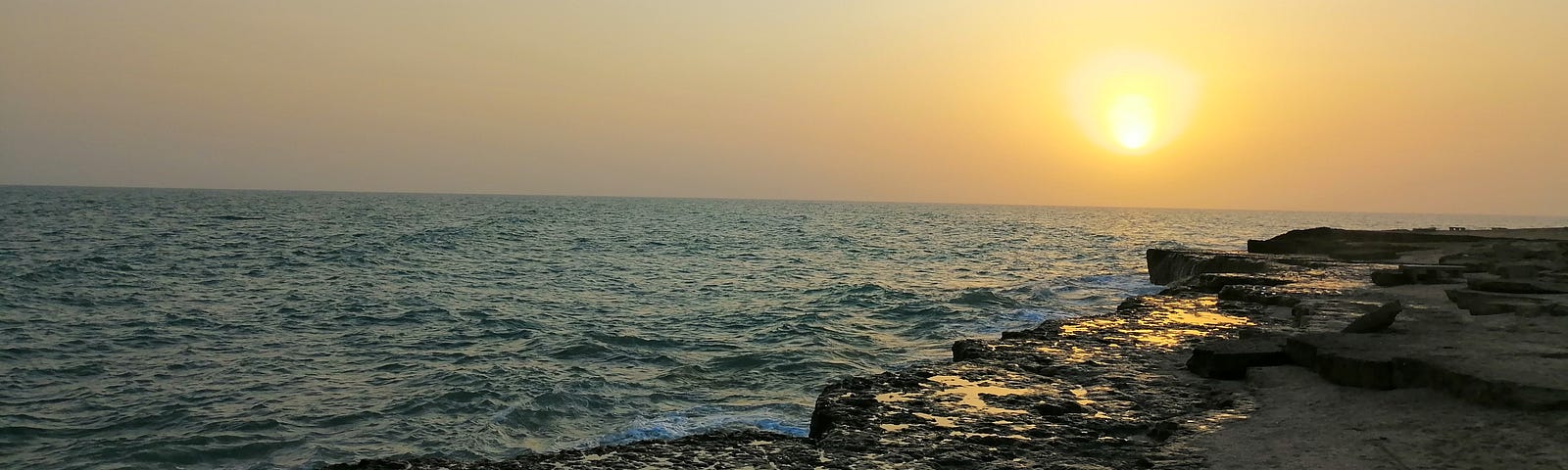 a pretty photo of an ocean with a sun setting on the horizon line