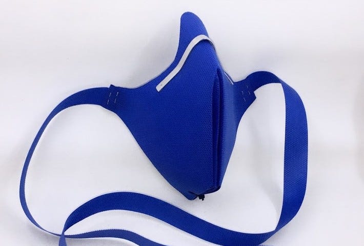 A blue origami face mask with a metal clip on a white background.