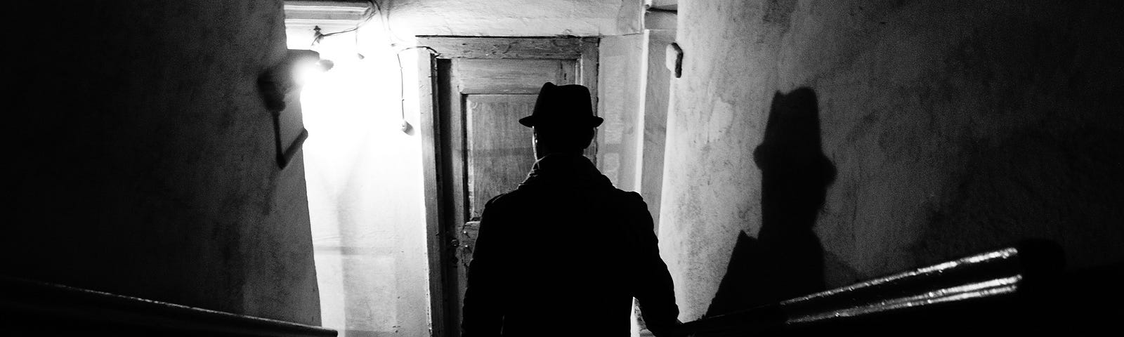 noir-style photograph of a figure descending a staircase
