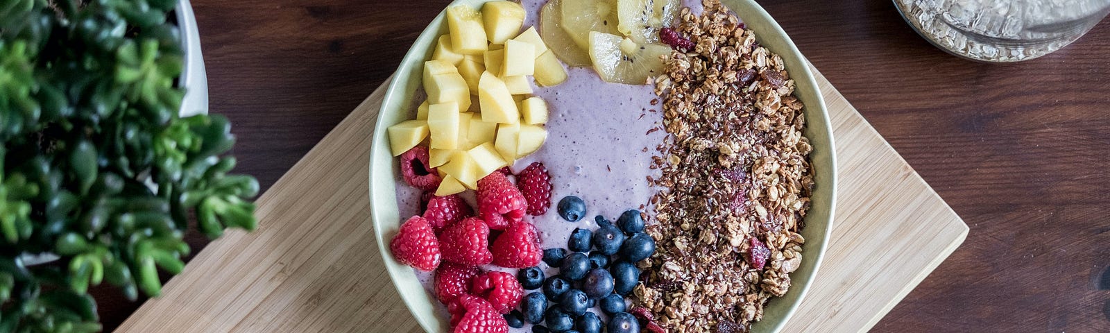 Table set with a large bowl of healthy grains and fruit.