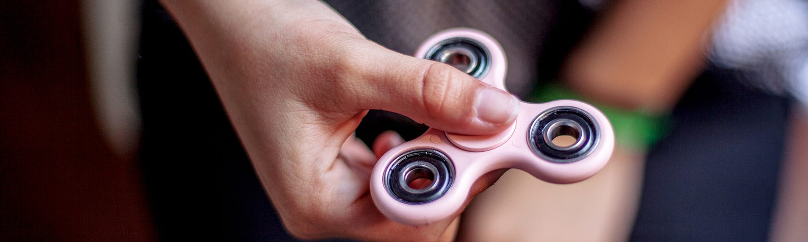 Teenager holding a fidget spinner.