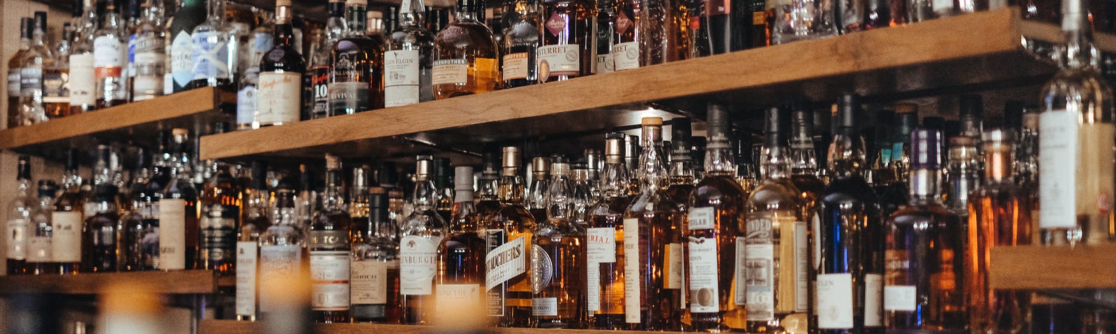 A bar whose shelves are filled with bourbon.