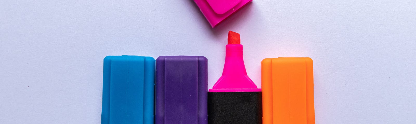Photo of highlighters in a row on a blank page.