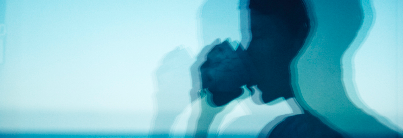 Blue reflection of person drinking from cup.